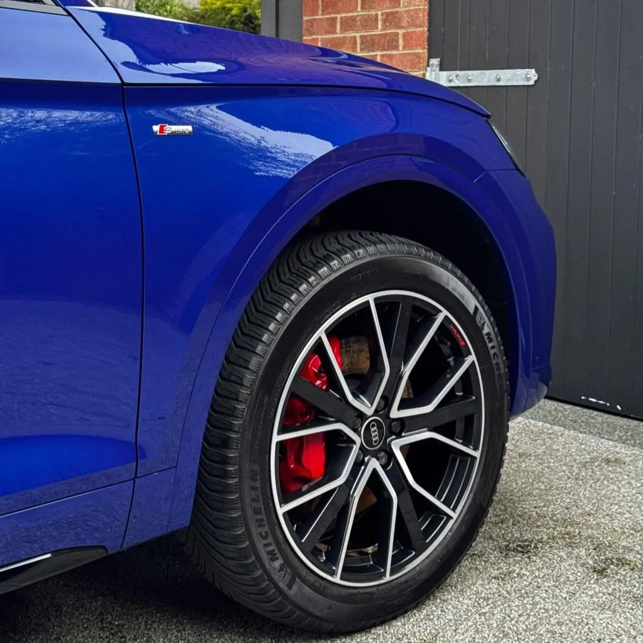 Glossy blue paint and a clean alloy wheel with red calipers